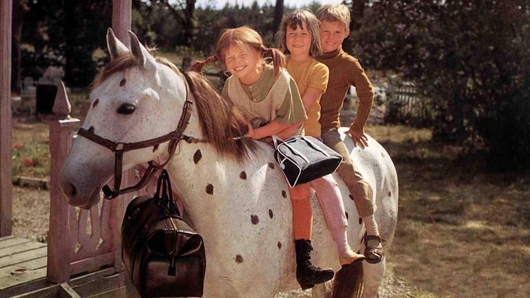Pippi Langstrumpf sitzt mit Annika und Tommy auf ihrem Pferd Kleiner Onkel