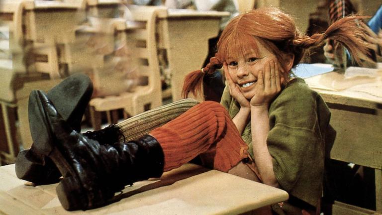 Pippi Langstrumpf in der Schule, die Füße sind auf dem Tisch