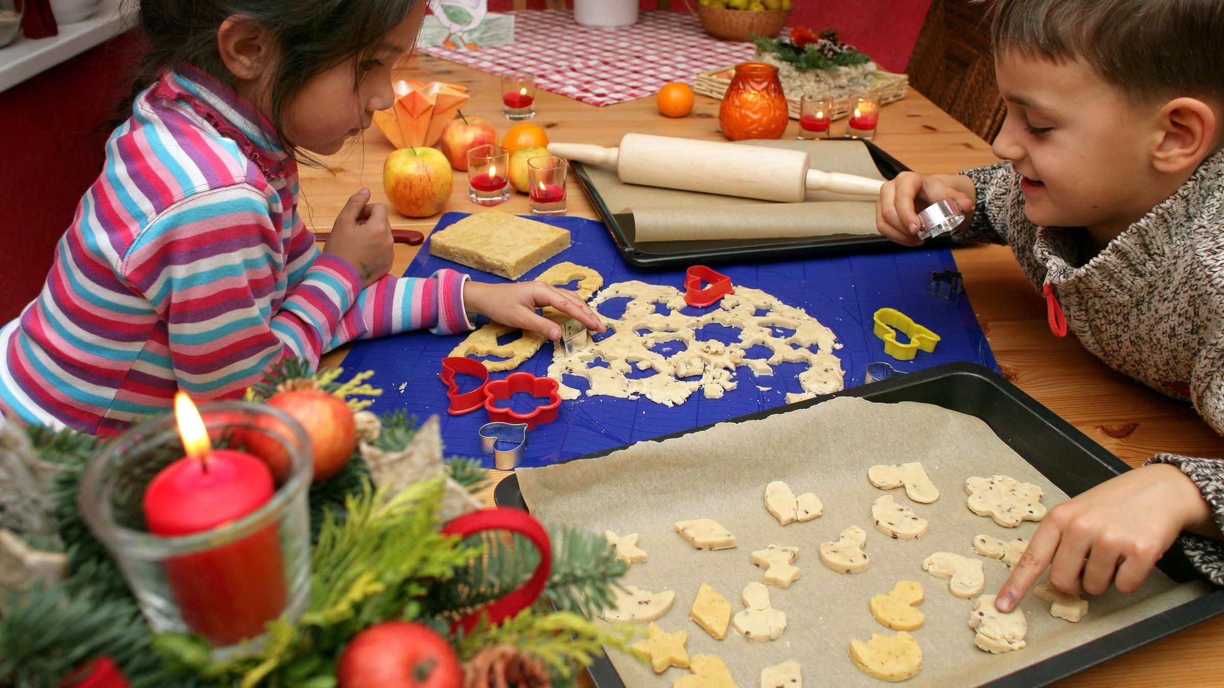 Kinder stechen Plätzchen aus.