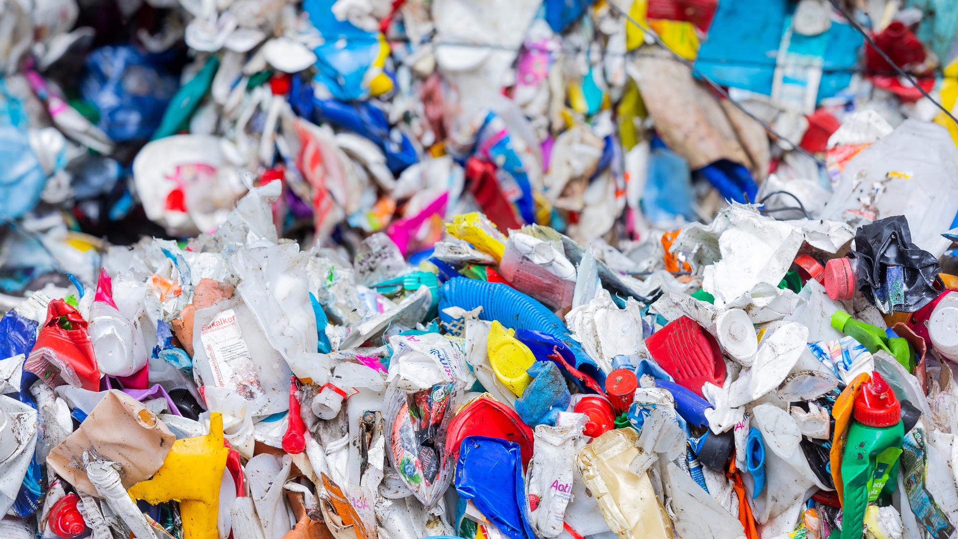 Sortierte Verpackungsabfälle stehen gepresst neben einer Halle in Erftstadt