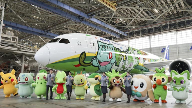 Pokémon Figuren stehen vor Flugzeug.