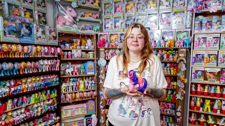 Frau steht vor ihrer Pony-Spielzeug Kollektion.