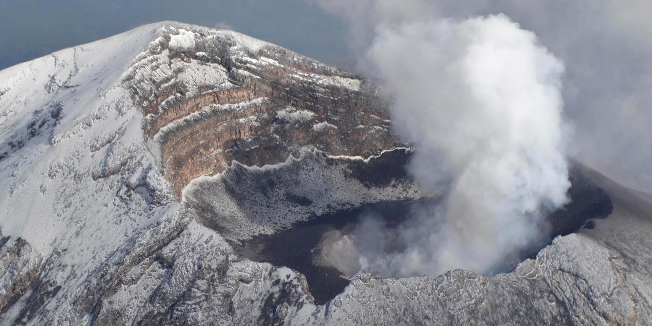 an aerial view of popocatepetl volcano spewing a column of smoke and ash 4,921 ft (1500 metres) high into the sky, in the outskirts of puebla is seen in this june 25, 2013 