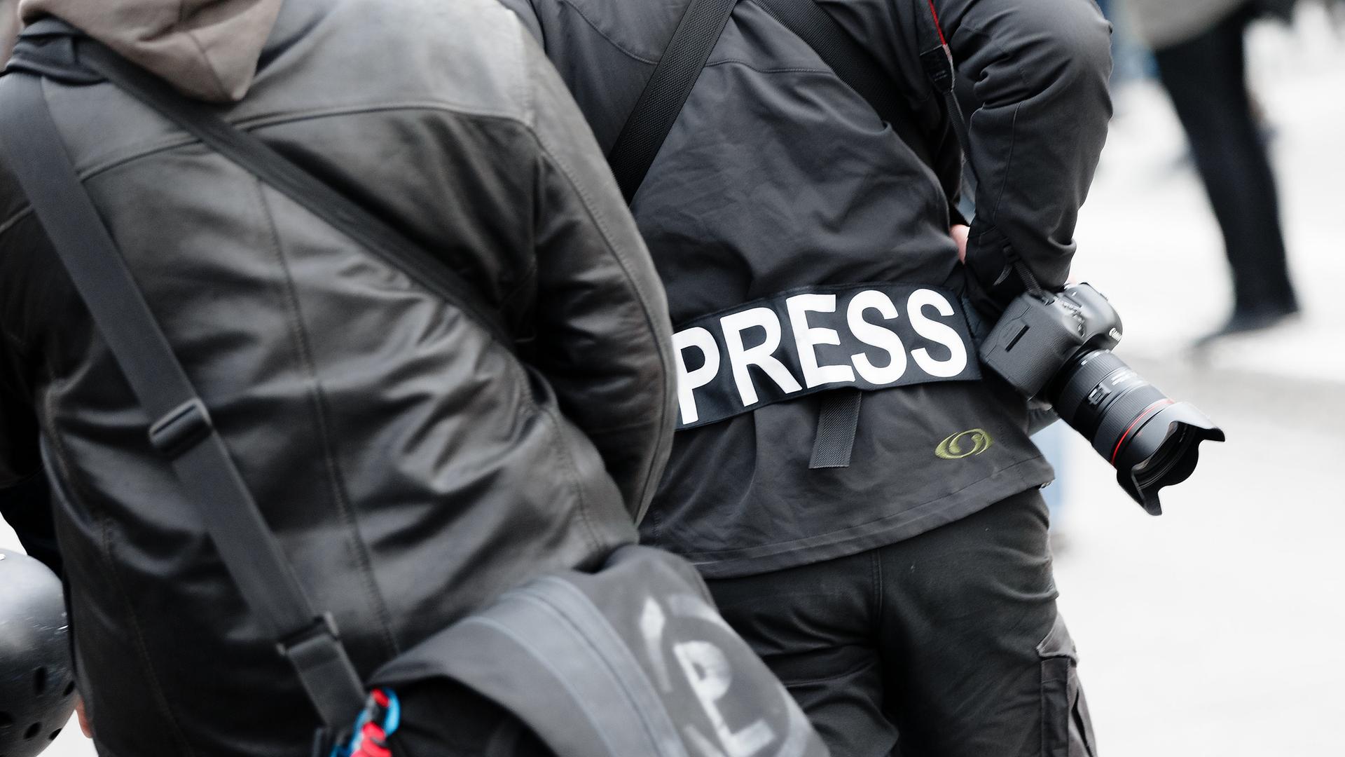 Ein Fotoreporter trägt bei einer Demonstration einen Aufnäher auf seiner Jacke mit dem Wort "PRESS". (Archiv)
