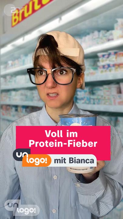 Bianca ist als Nerd verkleidet und steht mit einem Protein-Produkt vorm Supermarktregal