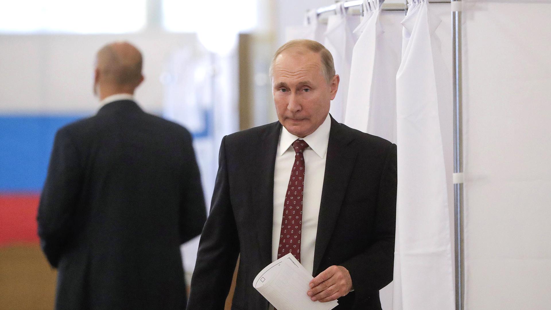 Präsident Wladimir Putin kommt aus einer Wahlkabine