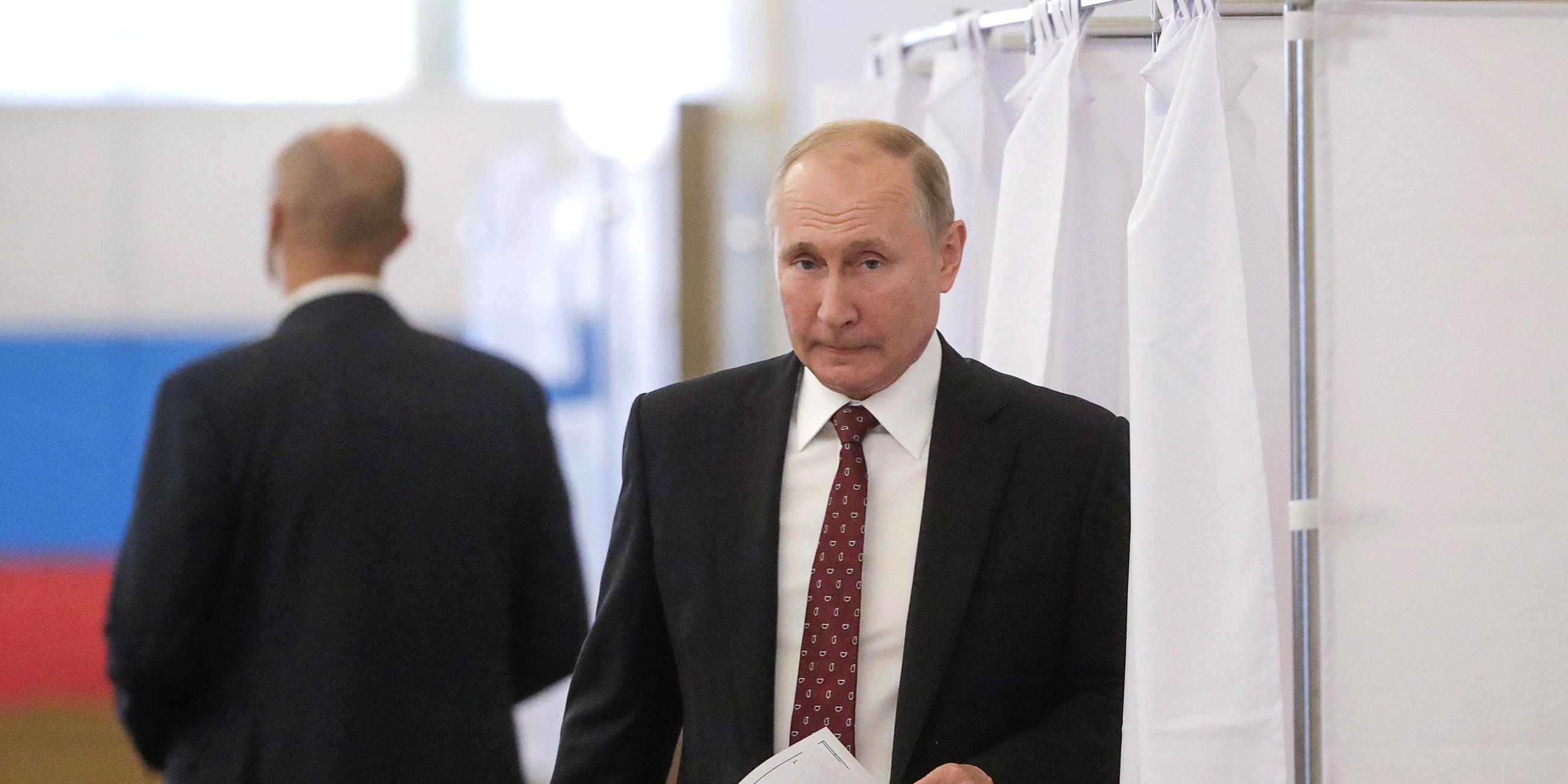Präsident Wladimir Putin kommt aus einer Wahlkabine