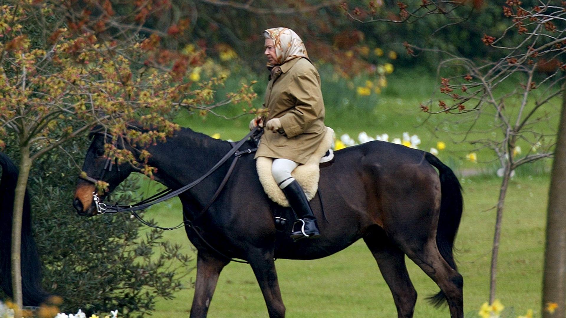 Queen Elizabeth reitet auf einem Pferd.