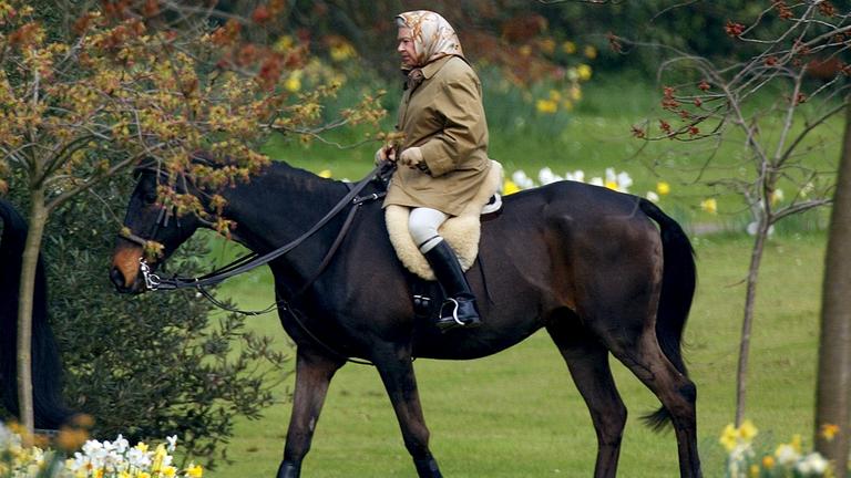 Queen Elizabeth reitet auf einem Pferd.
