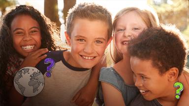 Es sind Kinder zu sehen, die in die Kamera lachen