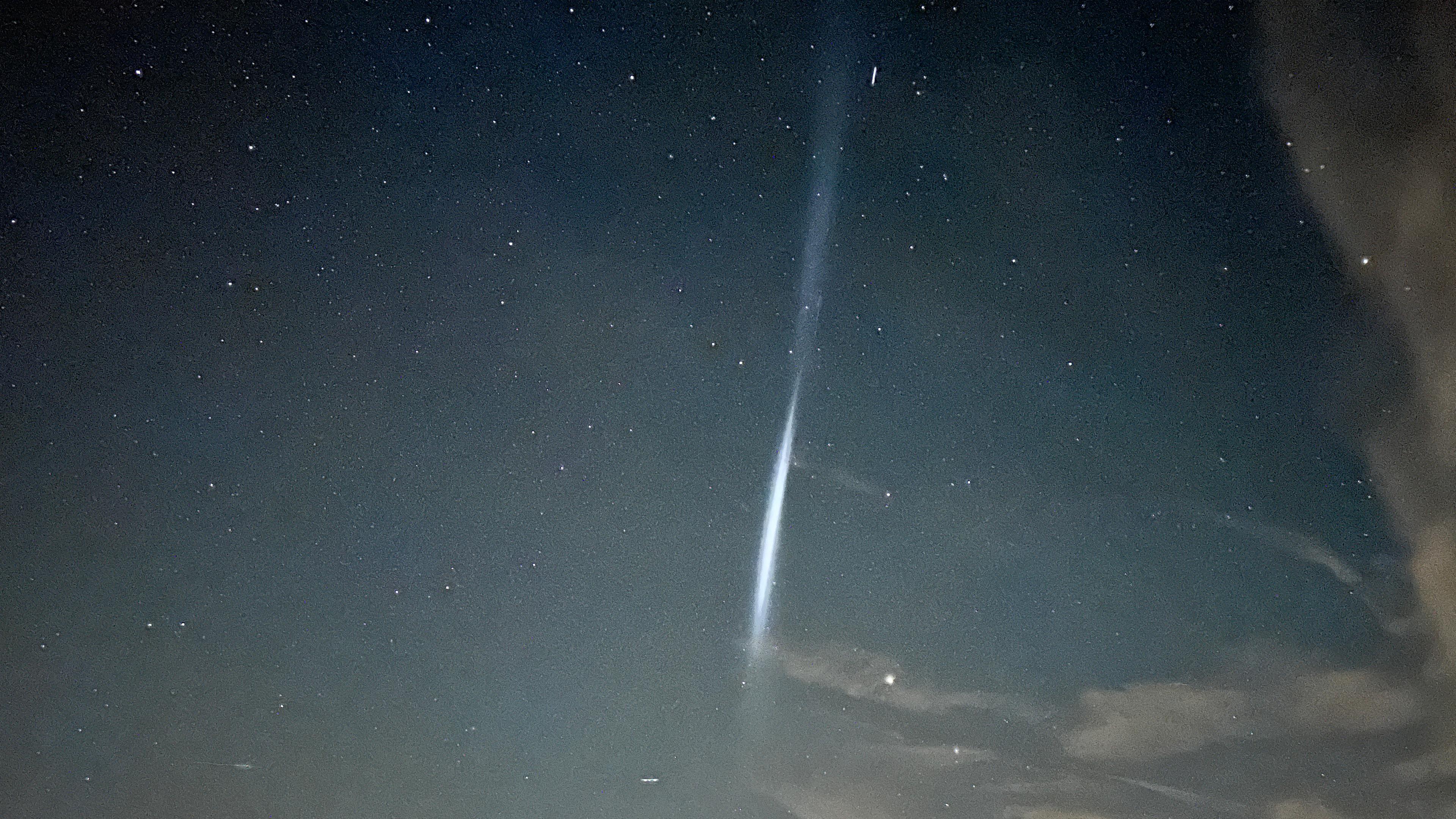 Ein Lichtschweif ist in der Nacht am Himmel zu sehen.