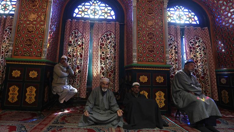 Muslimische Kinder und Erwachsene beten während des heiligen Monats Ramadan in einem großen Gebäude in Srinagar, Indien. Sie beten zu Ehren eines wichtigen religiösen Lehrers, Sheikh Syed Abdul Qadir Jeelani. Während Ramadan beten viele Menschen in der Nacht und verzichten tagsüber auf Essen und Trinken.