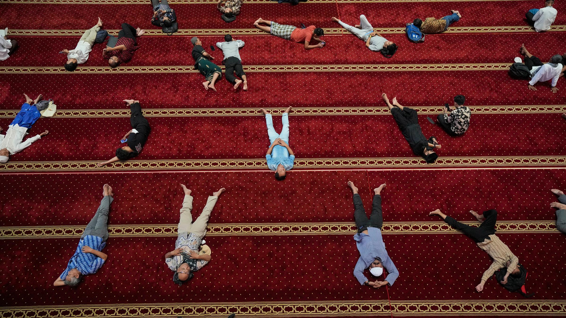 Viele muslimische Männer ruhen sich nach dem frühen Freitagsgebet in der Istiqlal Moschee in Jakarta aus.