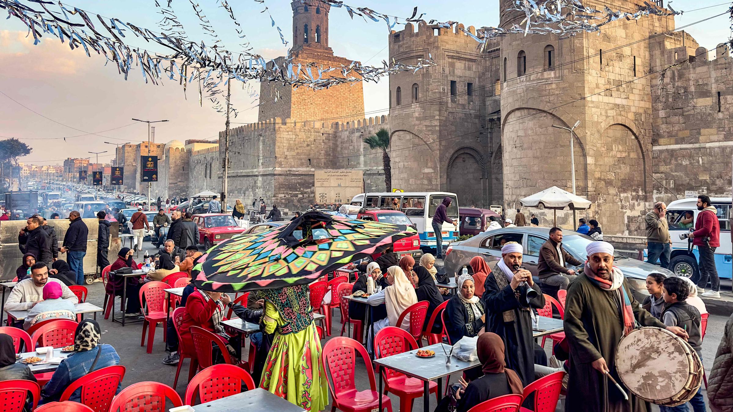 Ein Straßenmusiker läuft durch den Außenbereich eines Restaurants.