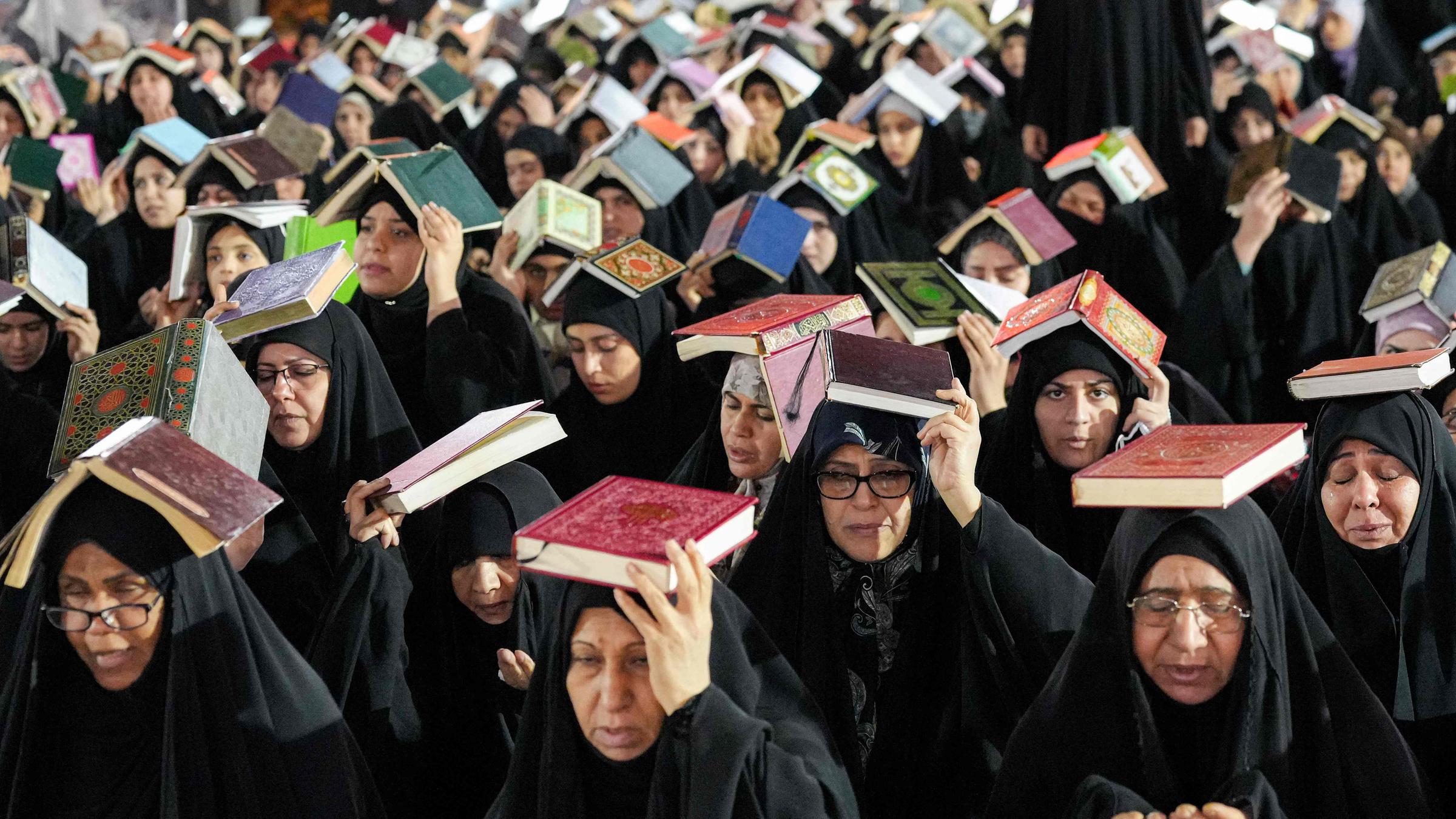 Viele muslimische Frauen tragen den Koran auf dem Kopf.