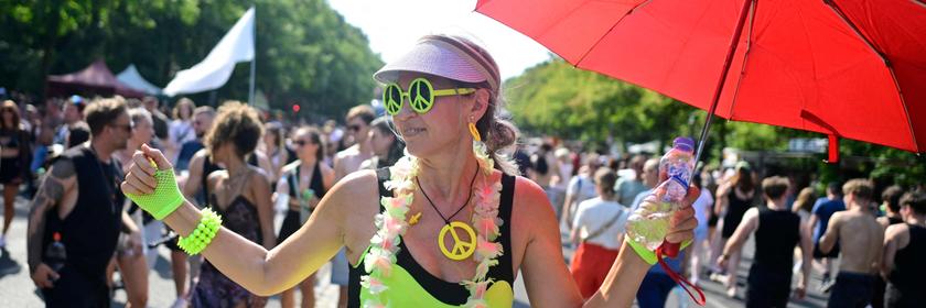 Menschen feiern auf einer Parade. Eine Frau trägt eine Piece-Kette. 