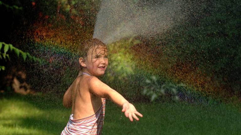 Regenbogen durch Wasser aus dem Gartenschlauch