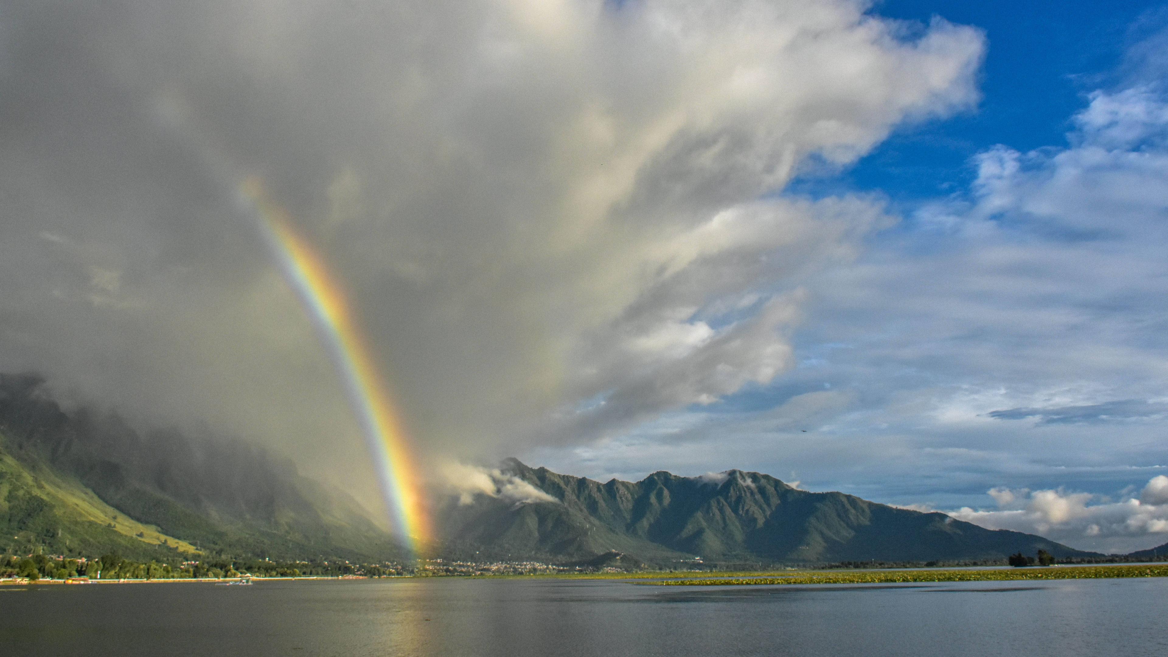 Ein Regenbogen erstreckt sich über einem Bergsee.