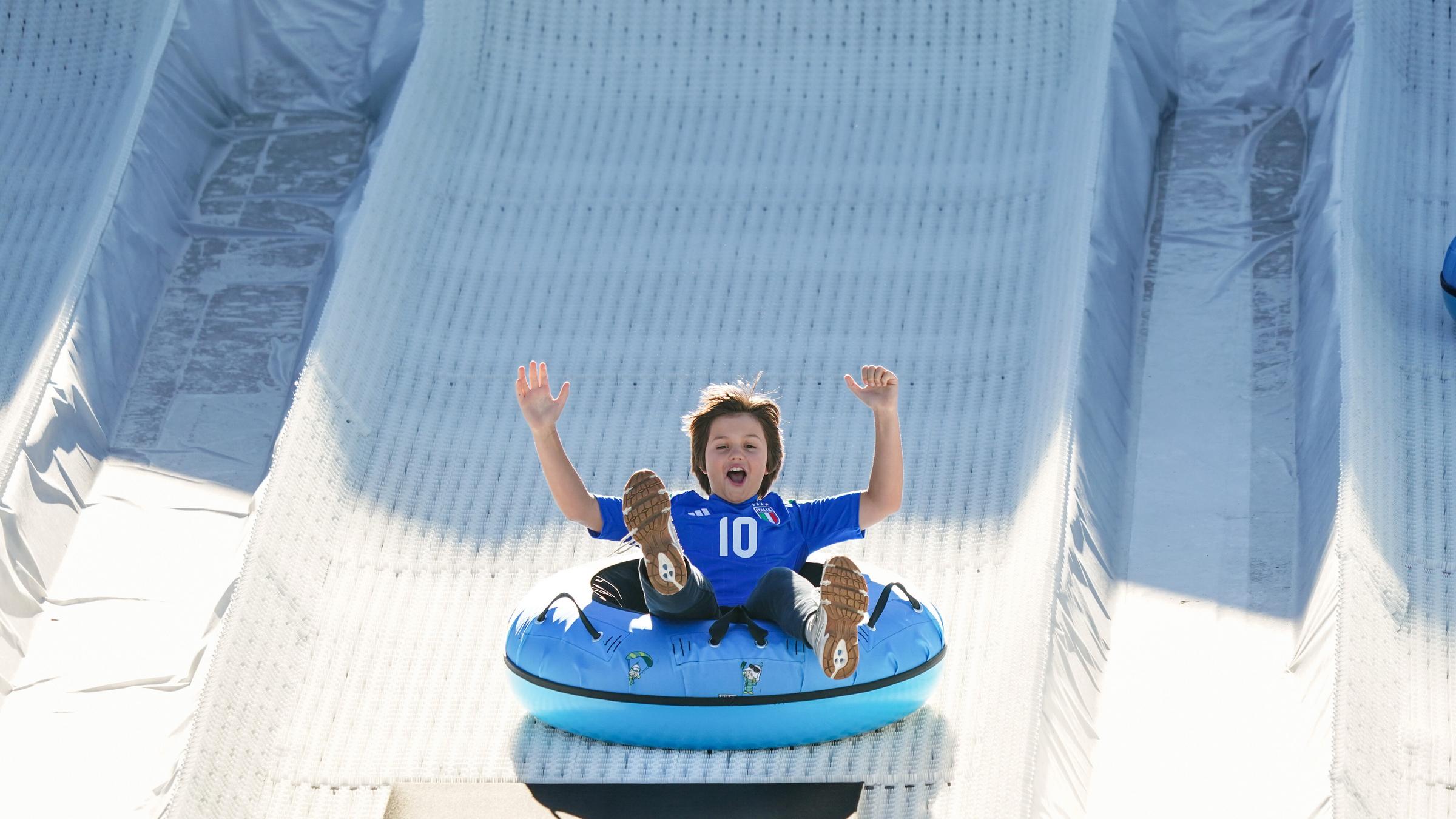 Kinder haben Spaß beim Reifenrodeln am Rande von Olympia