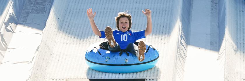 Kinder haben Spaß beim Reifenrodeln am Rande von Olympia