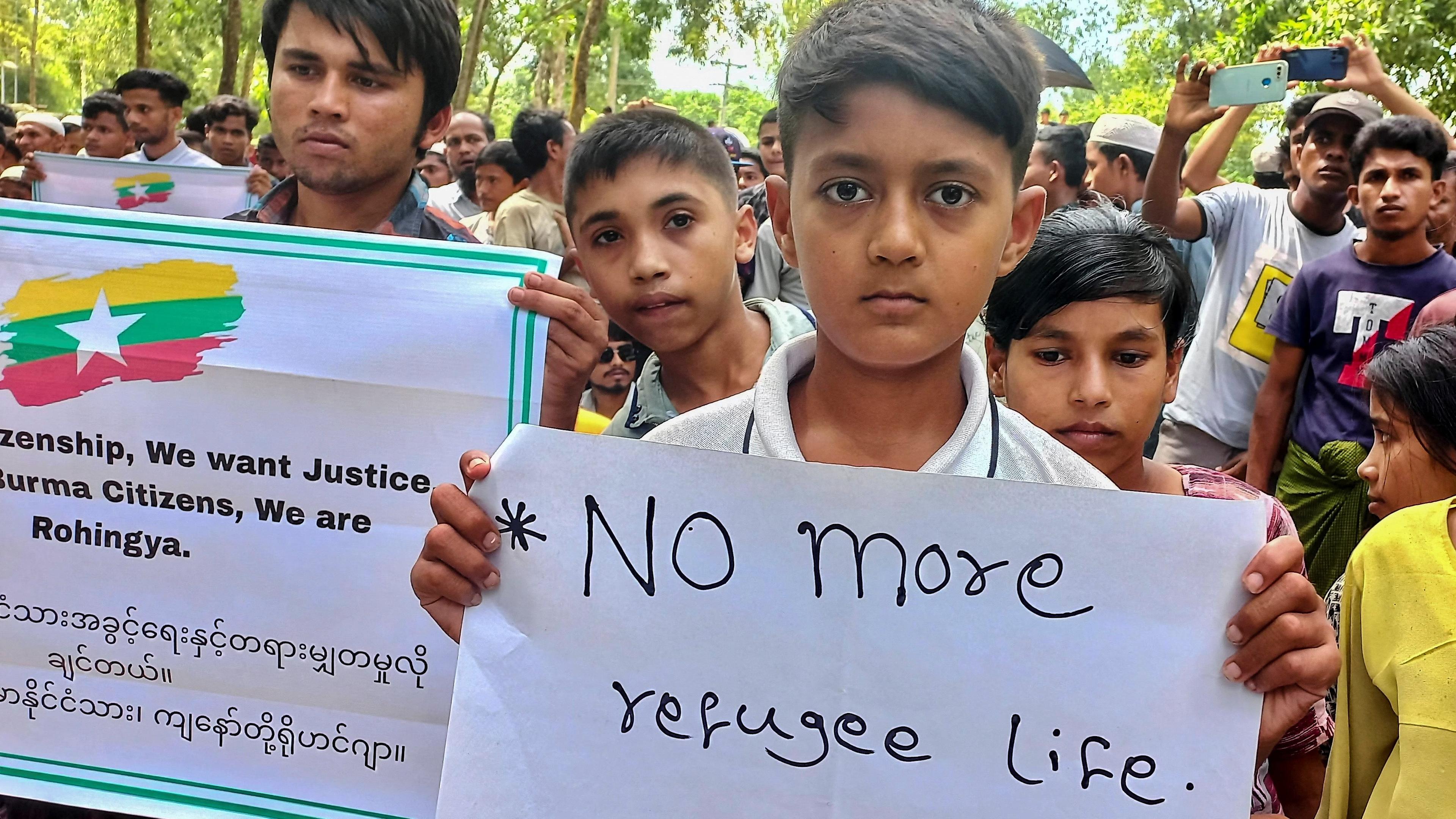Rohingya-Junge hält Plakat hoch: "Kein Leben als Flüchtling mehr"
