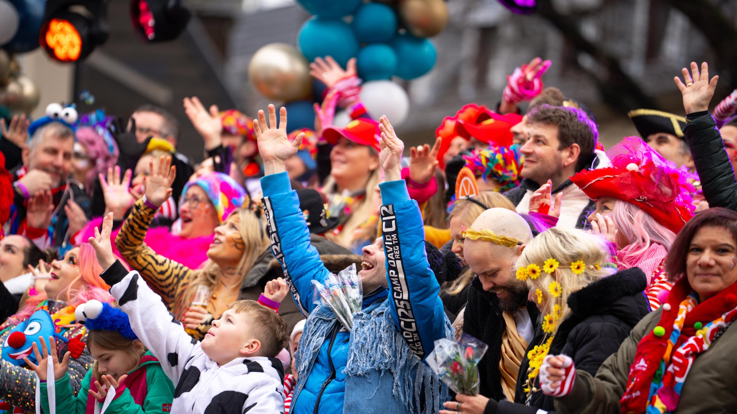 Die Jecken in Köln greifen nach den Süßigkeiten, die von den Umzugswagen fliegen. "Jecken" nennt man im Rheinland die Menschen, die gern Karneval feiern – das Wort "jeck" bedeutet "närrisch" oder "verrückt".