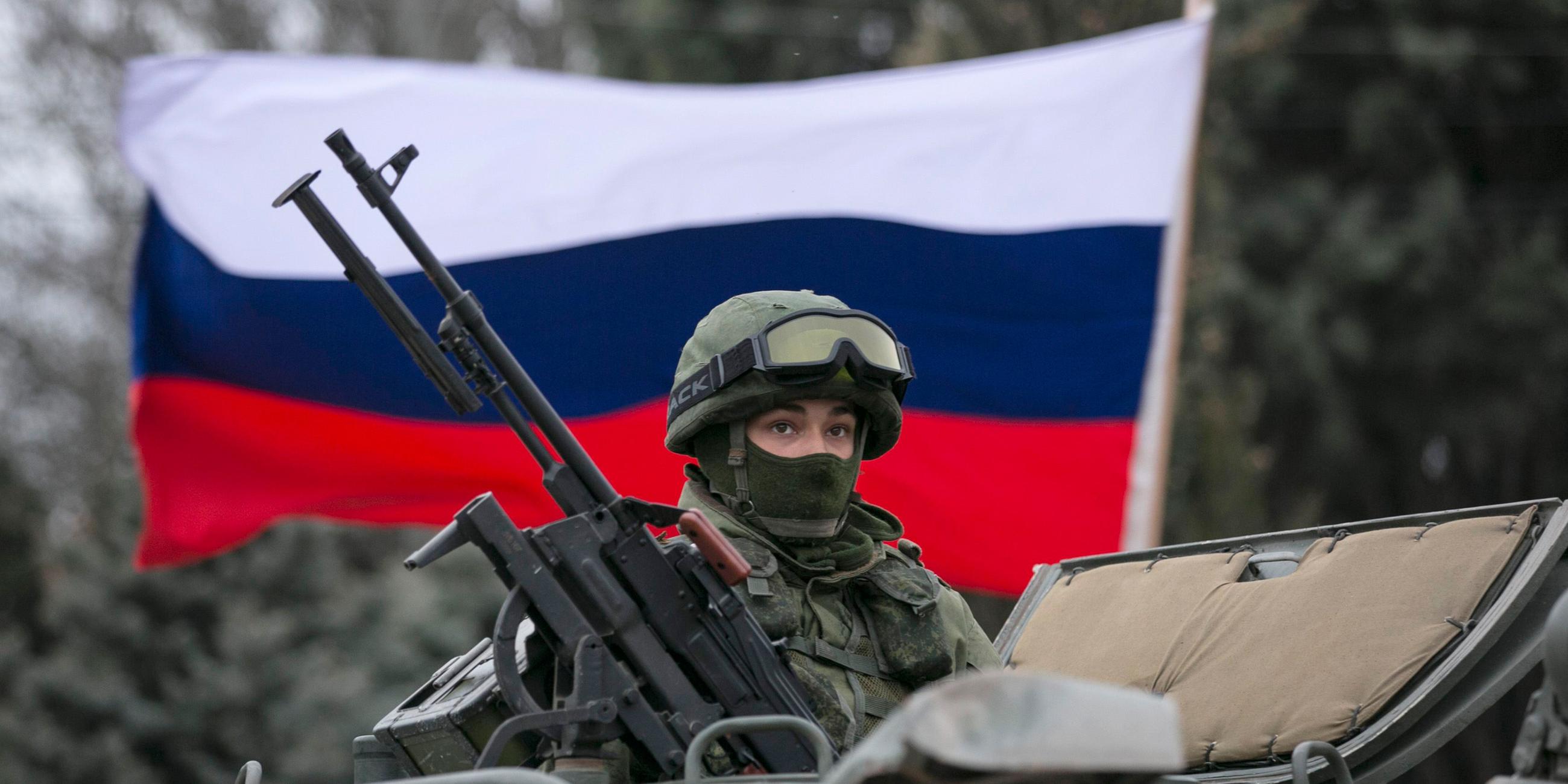 Russische Fahne hinter einem Soldaten im Panzer auf der Krim (Ukraine/Russland), aufgenommen am 01.03.2014