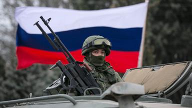 Russische Fahne hinter einem Soldaten im Panzer auf der Krim (Ukraine/Russland), aufgenommen am 01.03.2014