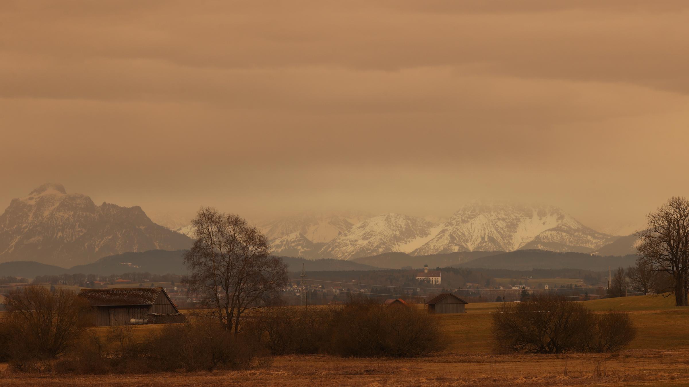 Staub aus der Sahara färbt den Himmel über dem Alpenvorland in rötliche Farbtöne