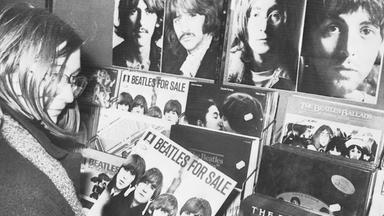 Frau hält eine Beatles Schallplatte in der Hand
