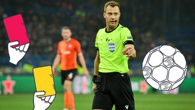 Ein Schiedsrichter, eine Trillerpfeife, ein Fußball, eine rote Karte und eine gelbe Karte
