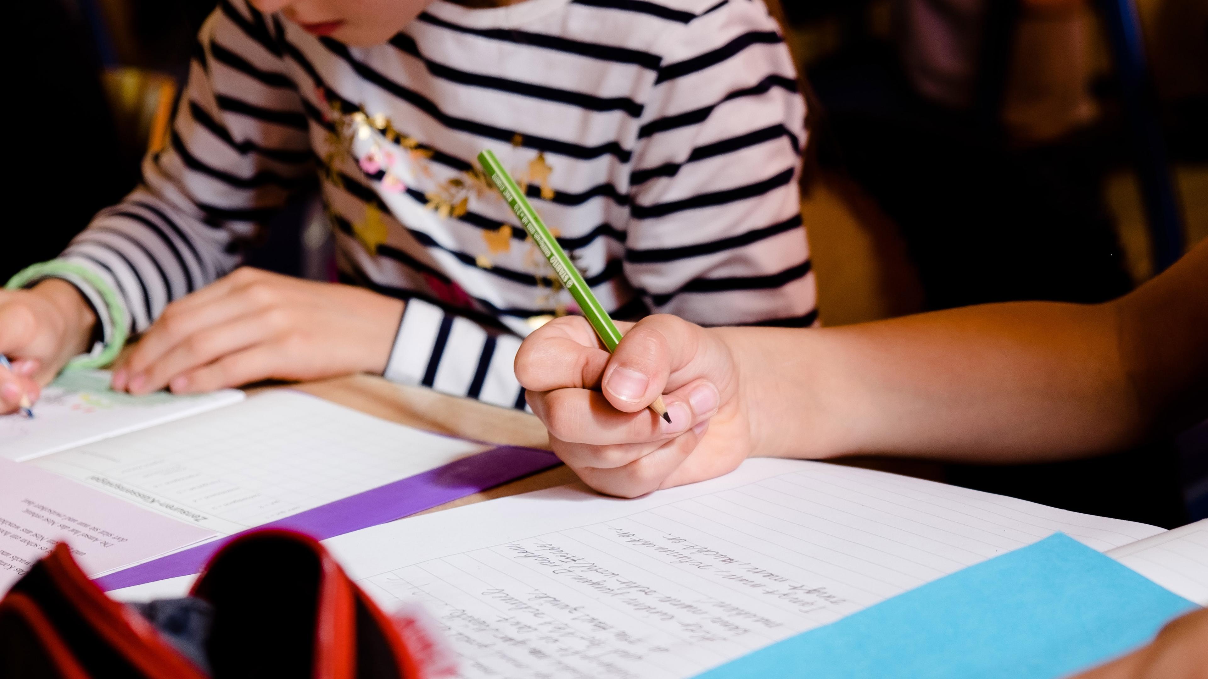 Schüler schreiben in ihre Schulhefte