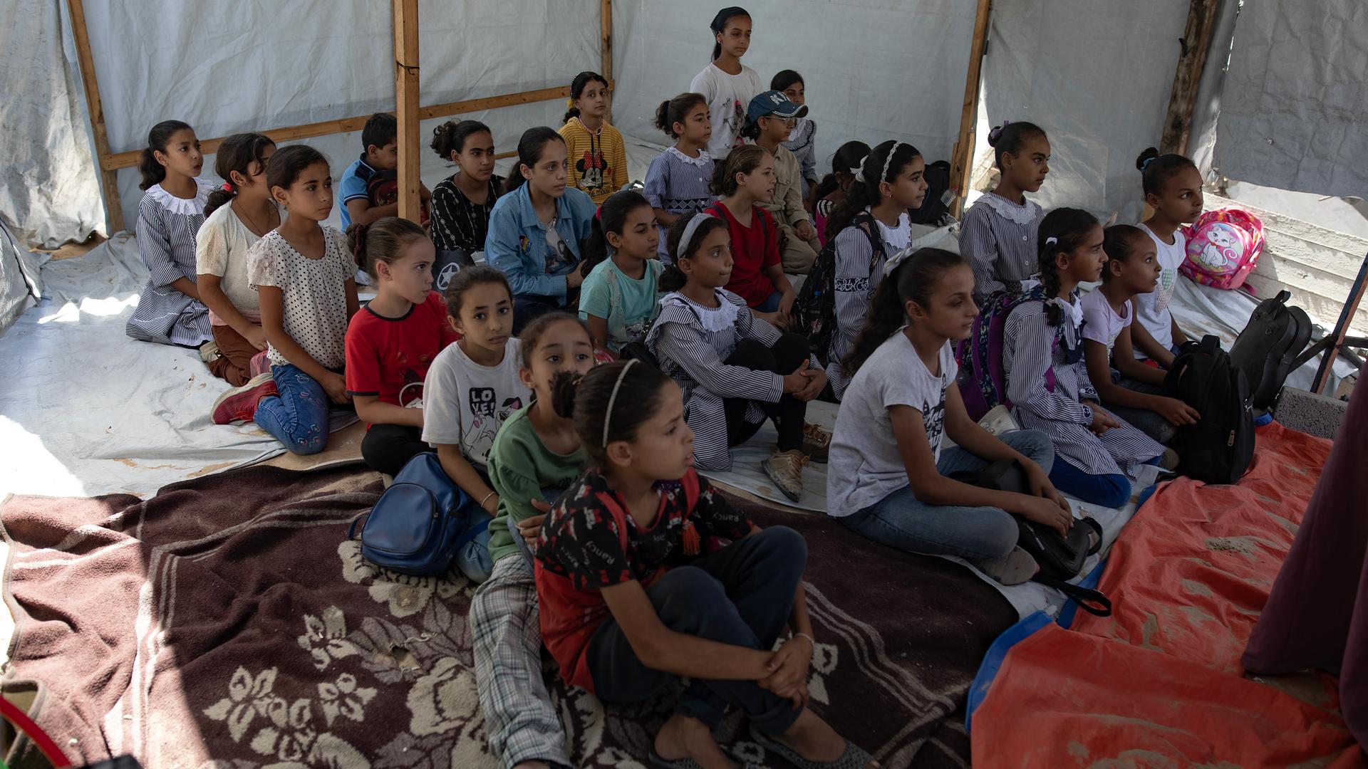 Schülerinnen und Schüler werden in einem Zelt im Gazastreifen unterrichtet.