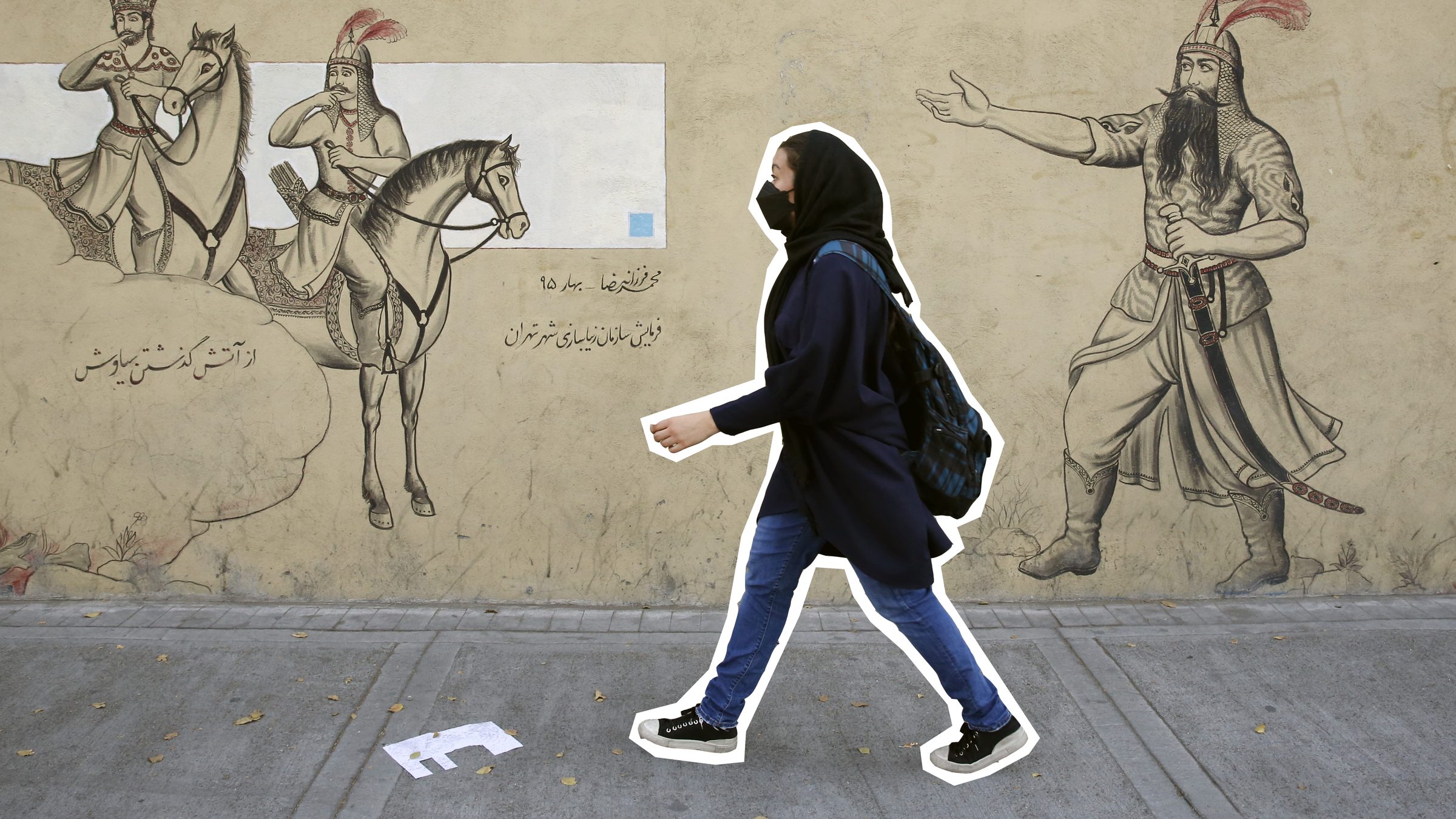 Ein Mädchen geht an einer Häuserfassade entlang.