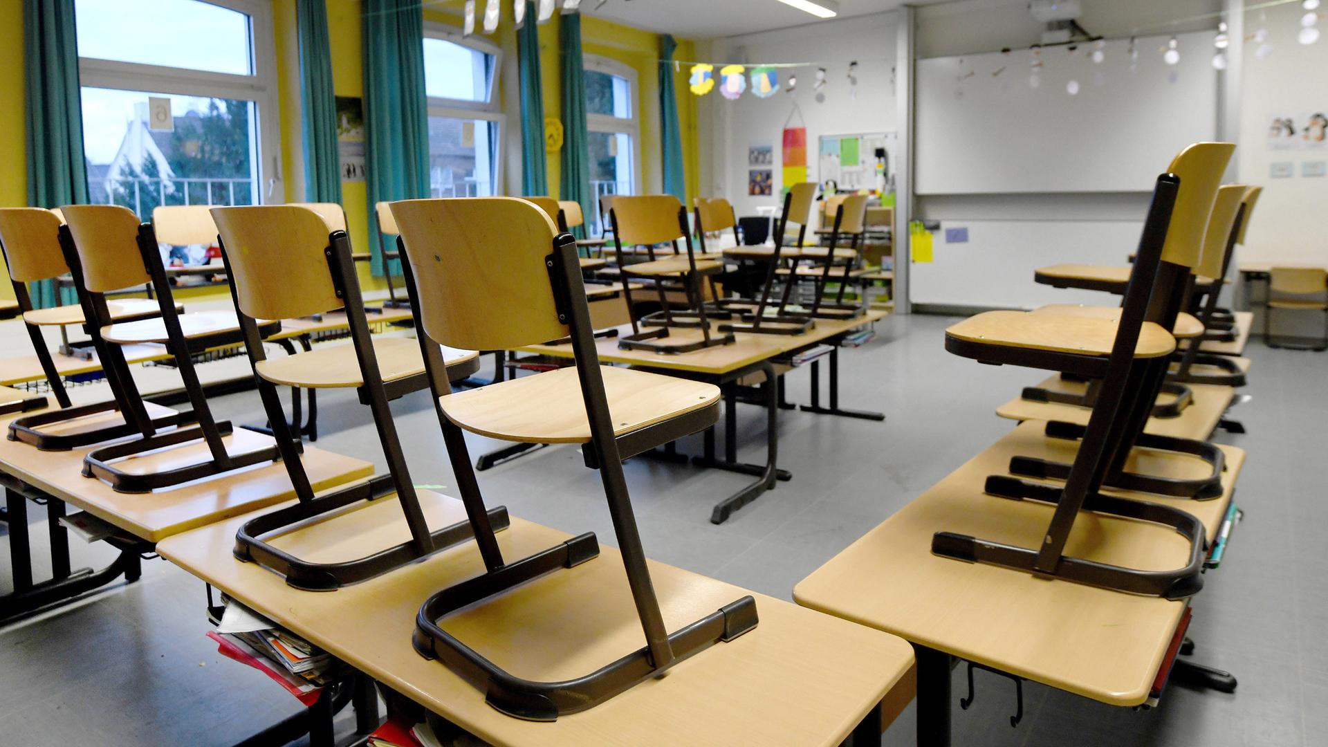 Stühle stehen in einem Klassenzimmer in einer Grundschule auf den Tischen. Der Lehrerverband fordert einen Notfallplan für Fälle von nötigen Schul-Lockdowns. 