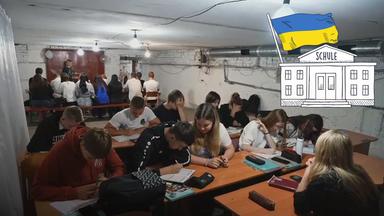 Kinder werden in Keller unterrichtet, darauf grafische Schule + ukrainische Flagge