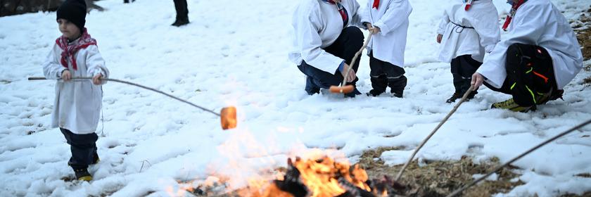 Kinder und ihre Väter machen in Untervaz in der Schweiz ein Lagerfeuer