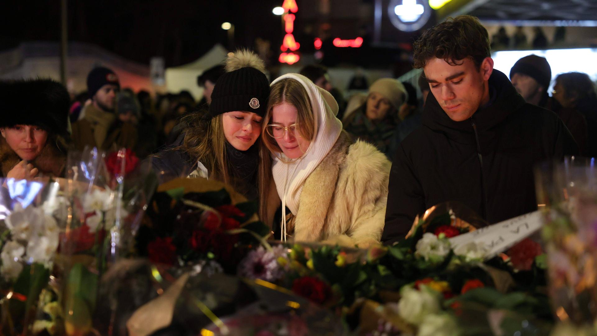Menschen gedenken der Opfer des Brandes in der Bar "Le Constellation"