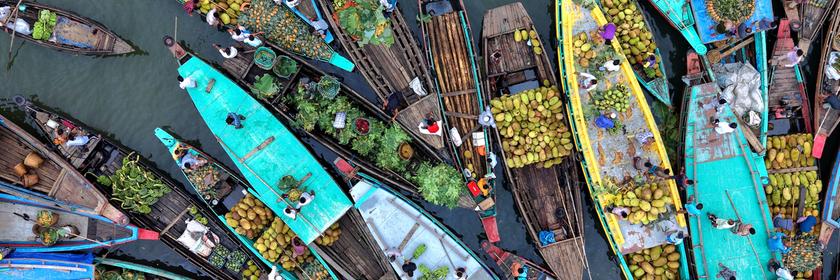 Bei einem schwimmenden Markt in Bangladesch verkaufen Bauern auf ihren Booten Obst und Gemüse.
