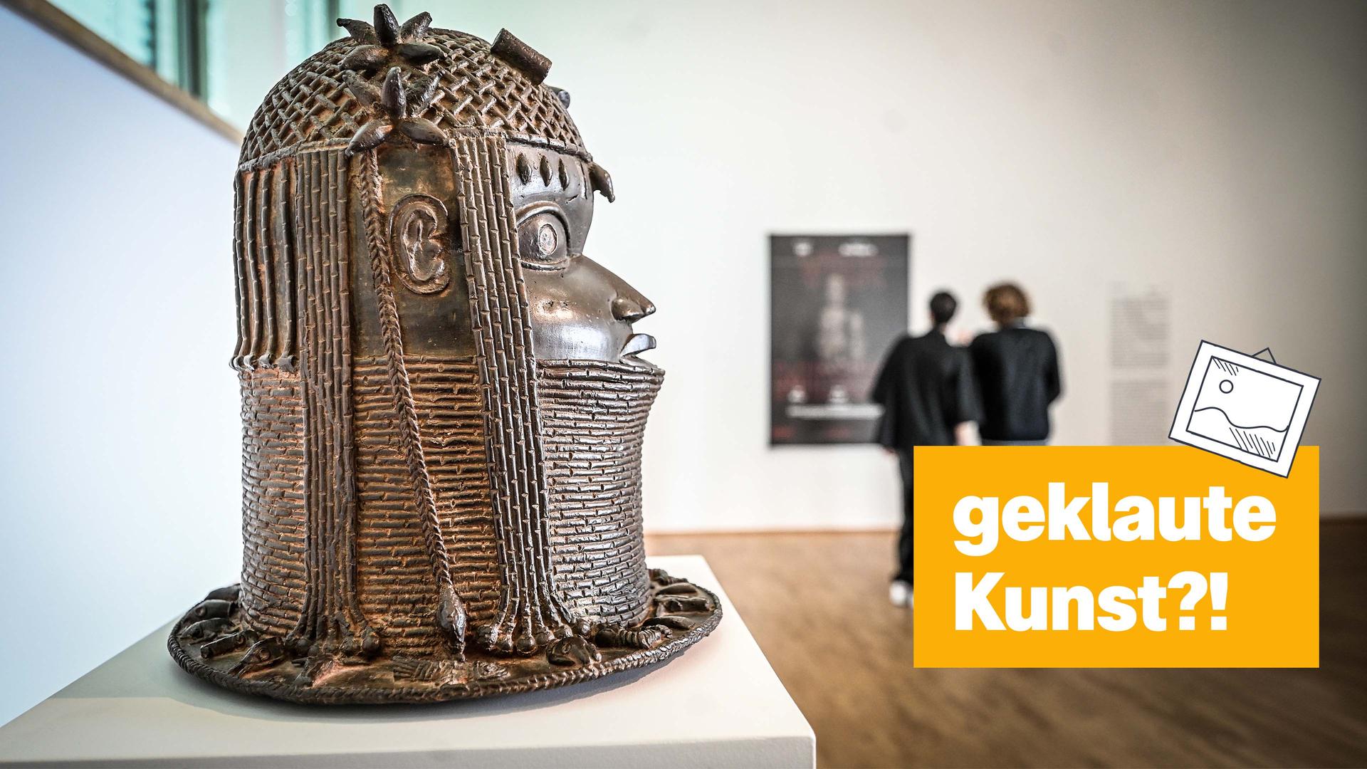 Ein Museum, in dem links einer Bronze-Skulptur eines Kopfes steht. Rechts daneben der Text: "geklaute Kunst?!"