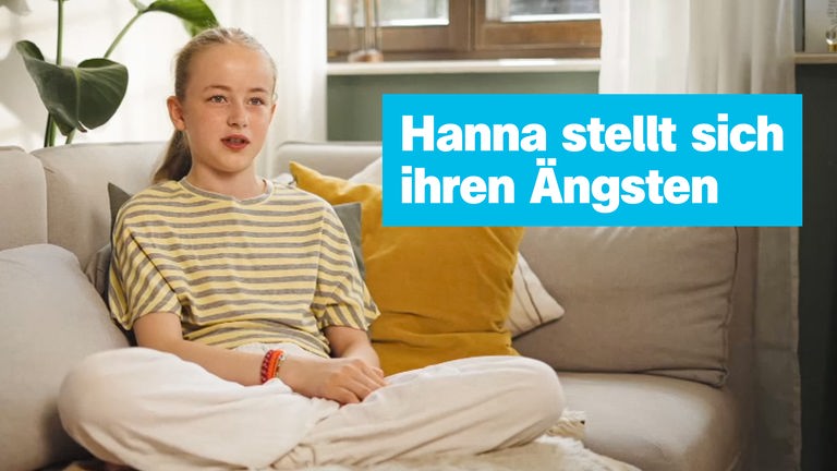 Hanna sitzt auf dem Sofa