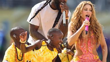 Grafik: Shakira und Burner Boy singen mit Mikrofon neben tanzenden Kindern.