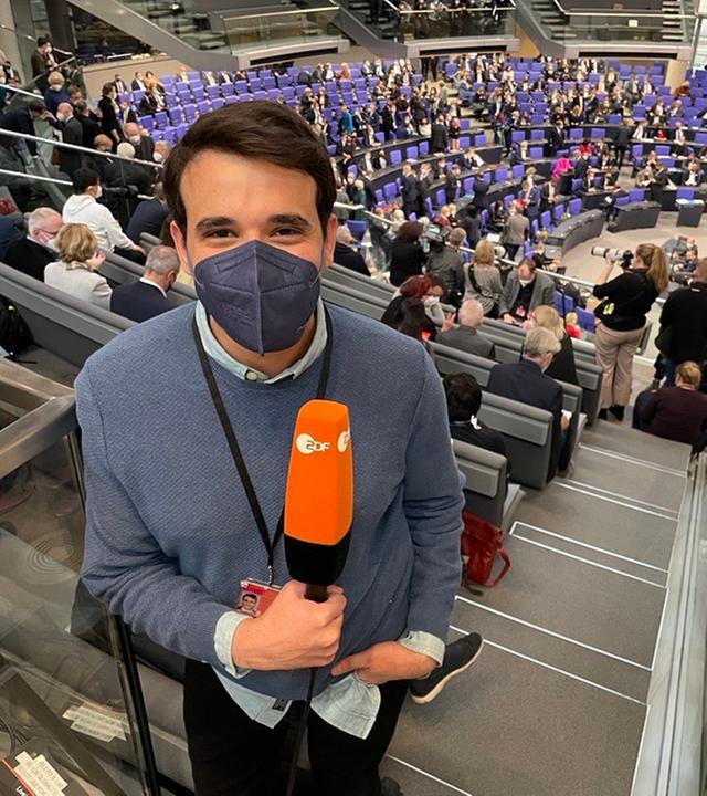Sherif steht mit Mikrofon im Bundestag.