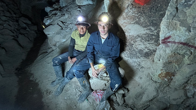 Sherif sitzt neben einem Jungen in einer Mine