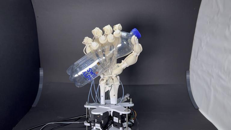 Eine Roboterhand hält eine Plastikflasche