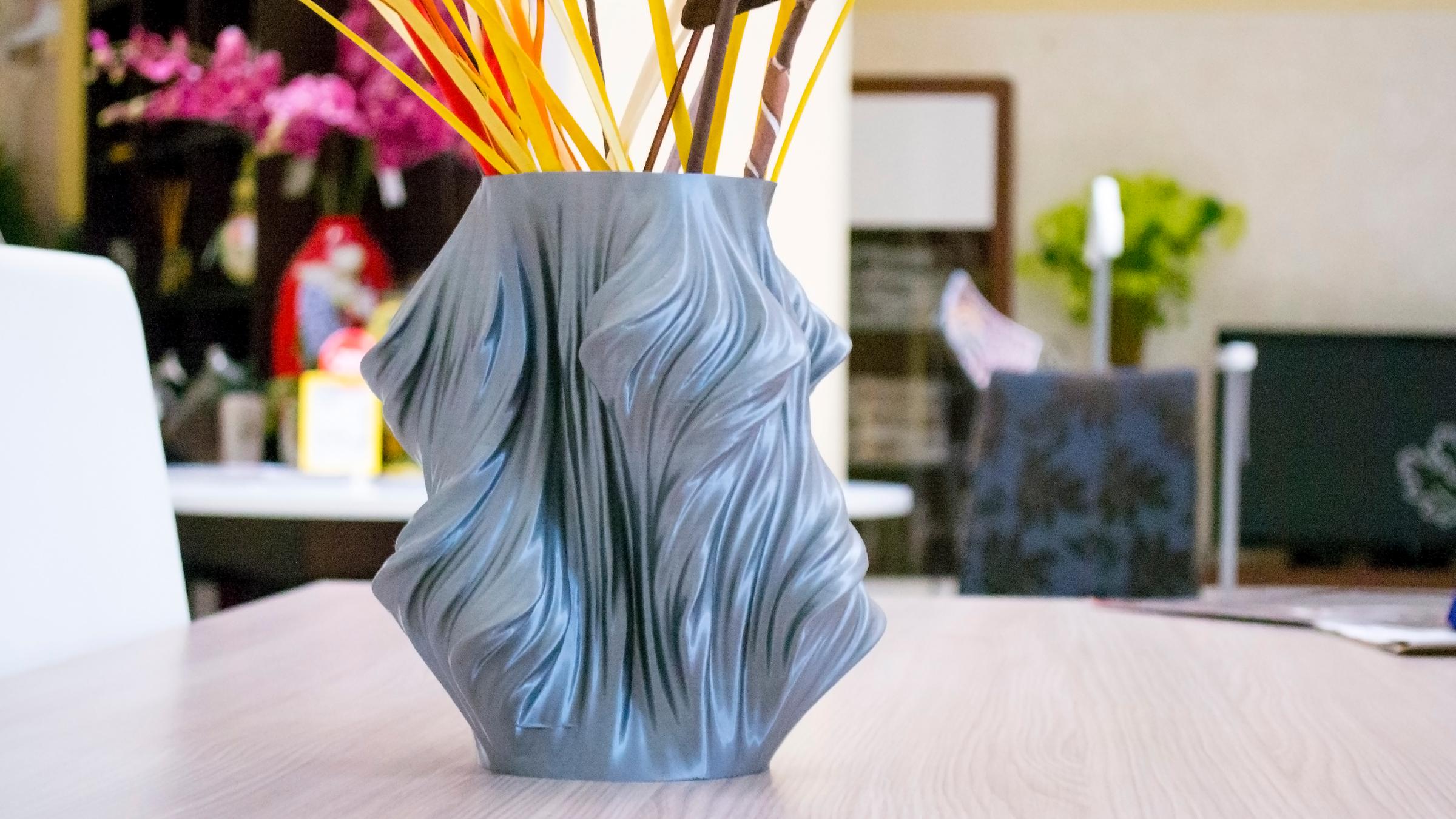 Eine Vase steht auf einem Tisch darin sind Blumen