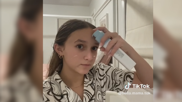 Zwei Mädchen stehen mit Augenpads vor Spiegel und lachen.