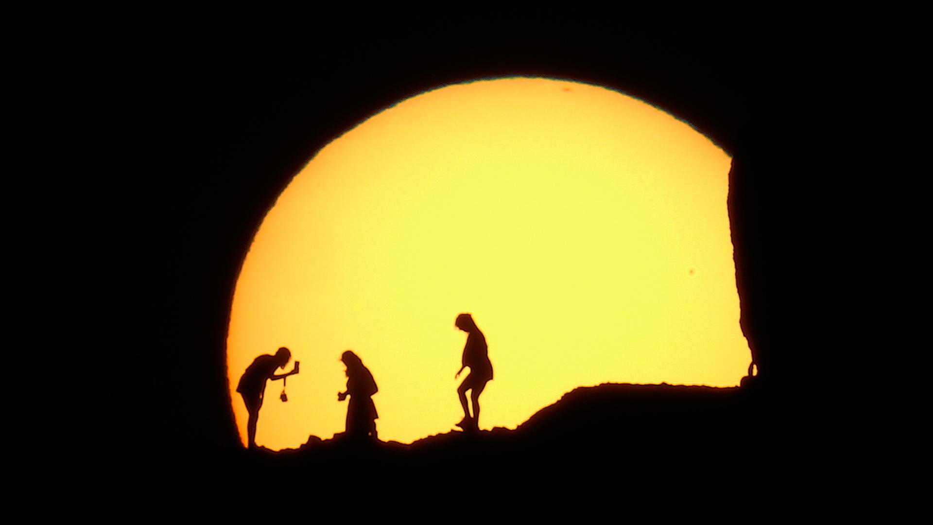 Menschen stehen vor der untergehenden Sonne in Arizona