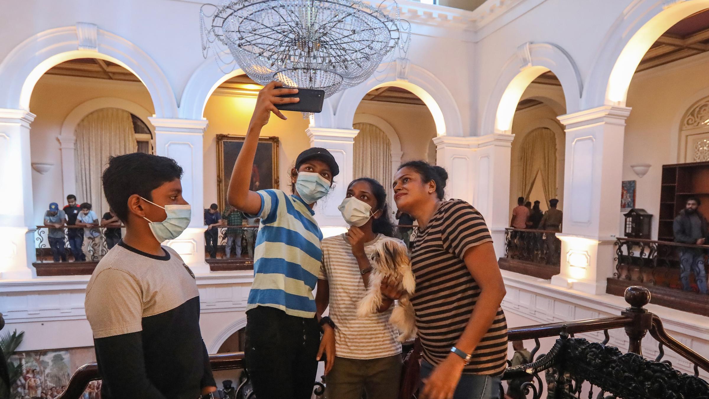 Protestierende machen Selfies im Präsidentenpalast. 