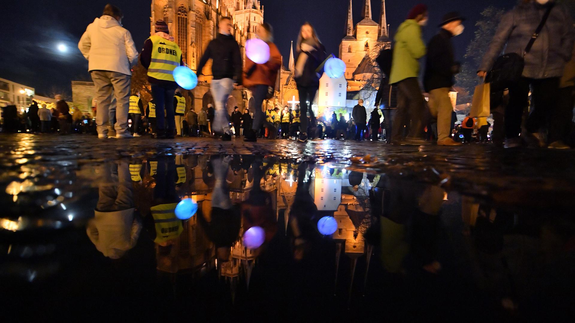 Kinder gehen in der Dämmerung mit Laternen spazieren, vorneweg reitet jemand als St. Martin verkleidet.